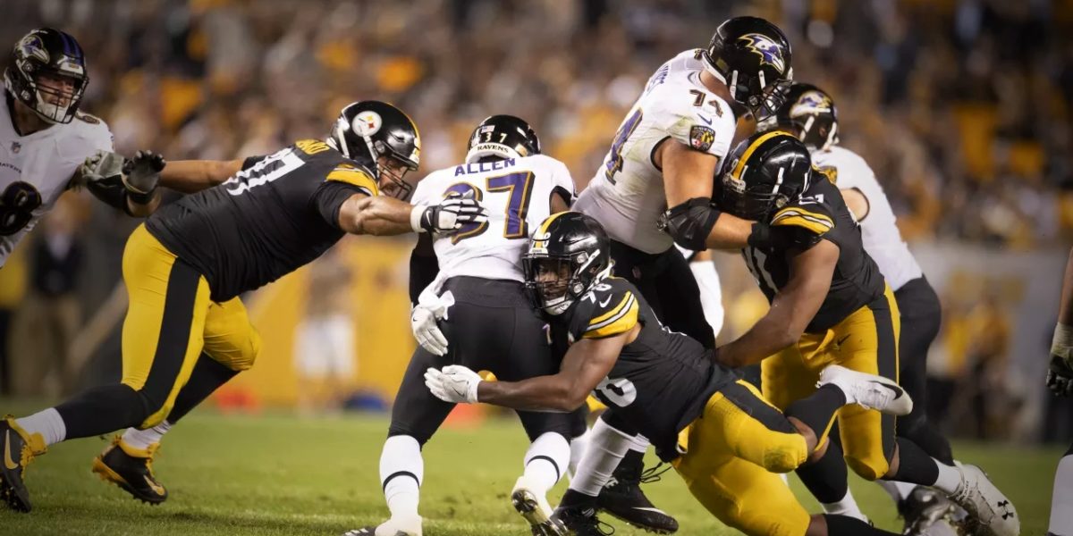 Steelers linebacker Vince Williams is assisted by Cam Heyward in tackling a Baltimore Ravens rusher