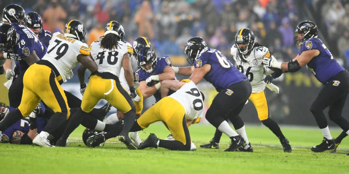 Pittsburgh Steelers defenders surround Baltimore Ravens quarterback Lamar Jackson in a 2019 regular season NFL game in Baltimore