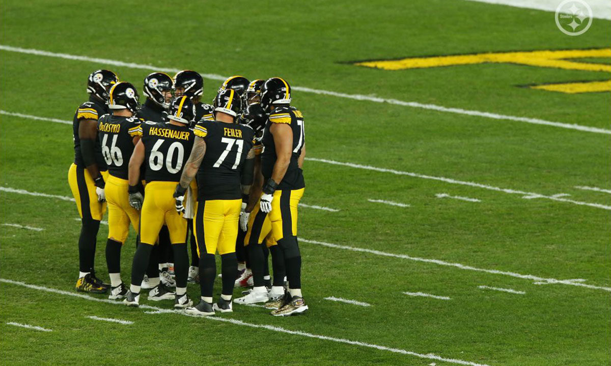 Pittsburgh Steelers center J.C. Hassenauer (#60) huddles up
